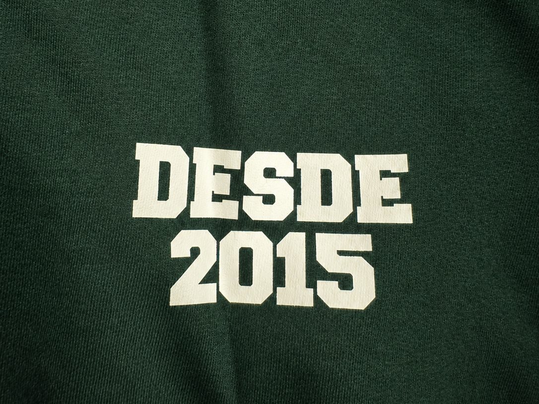 Close de estampa em silk em camiseta verde: texto Desde 2015 em creme, com a tinta bem fixada no tecido