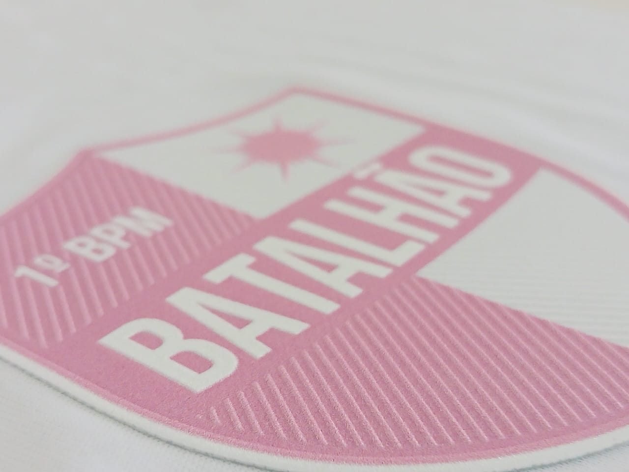 Brasão 1º BPM Batalhão em TPU rosa aplicado em camiseta branca, com textura em relevo